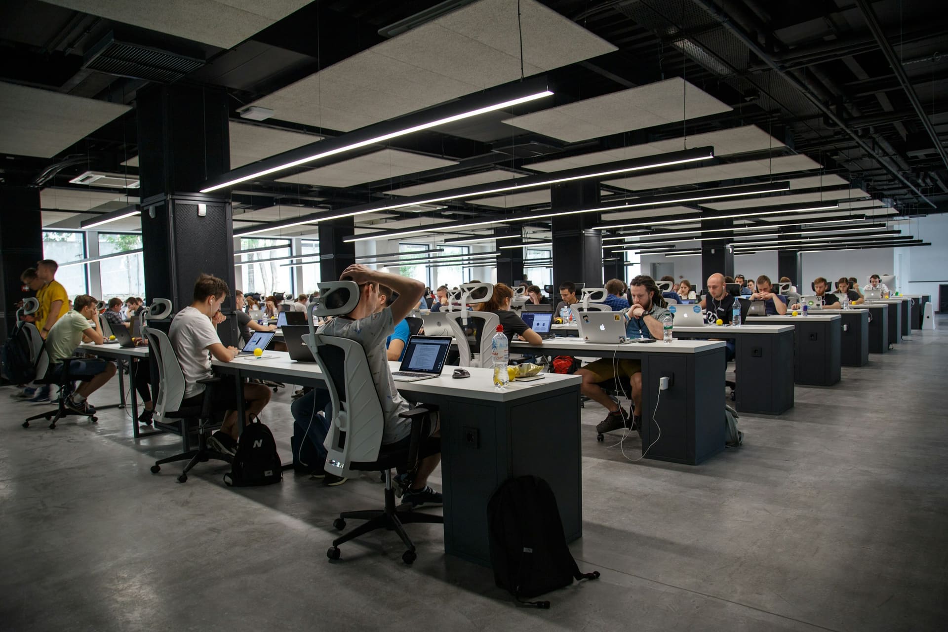 Business technology context: a large office floor of equipped desks.