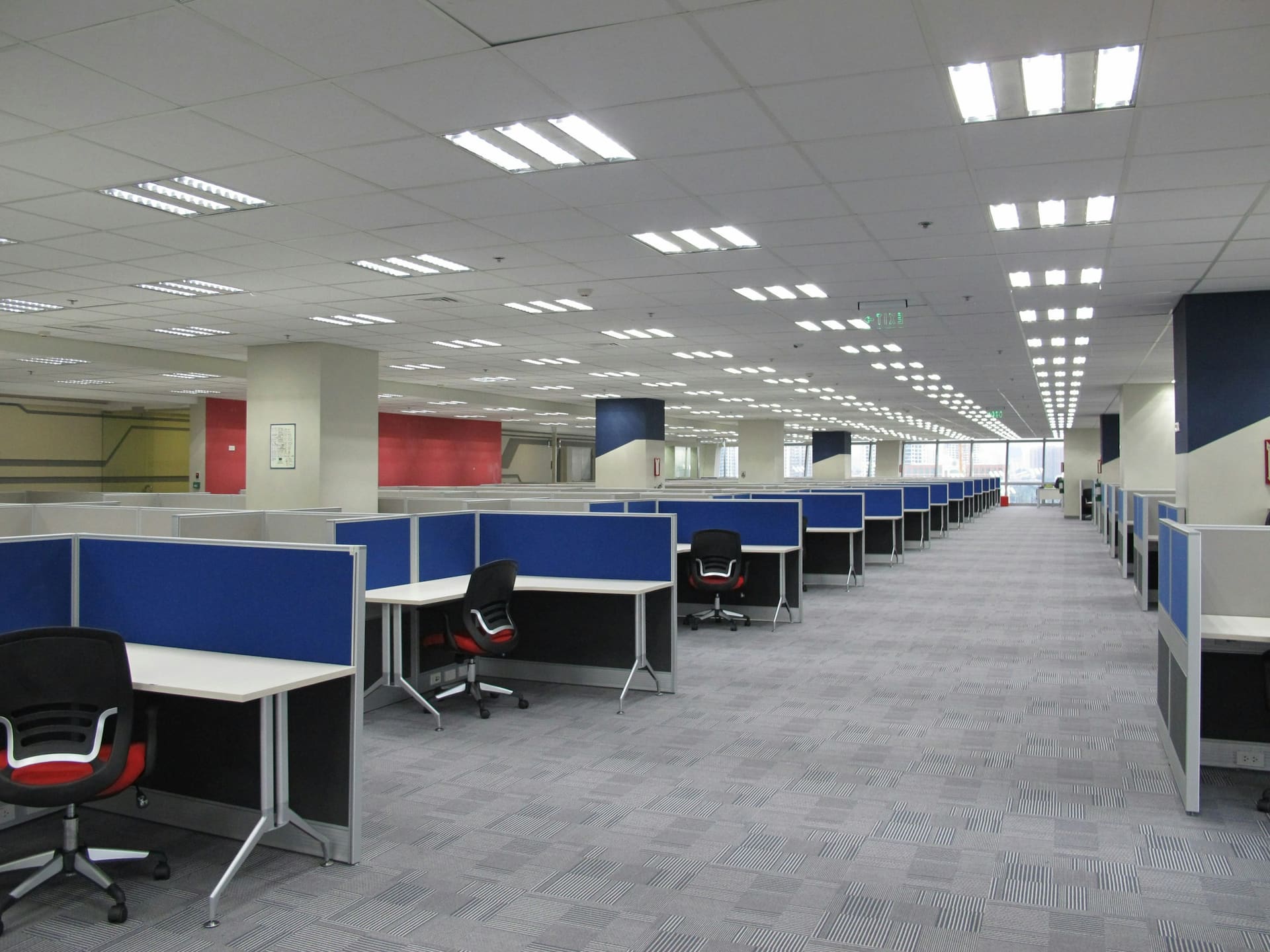 Business technology context: rows of workstations in an open-plan office.