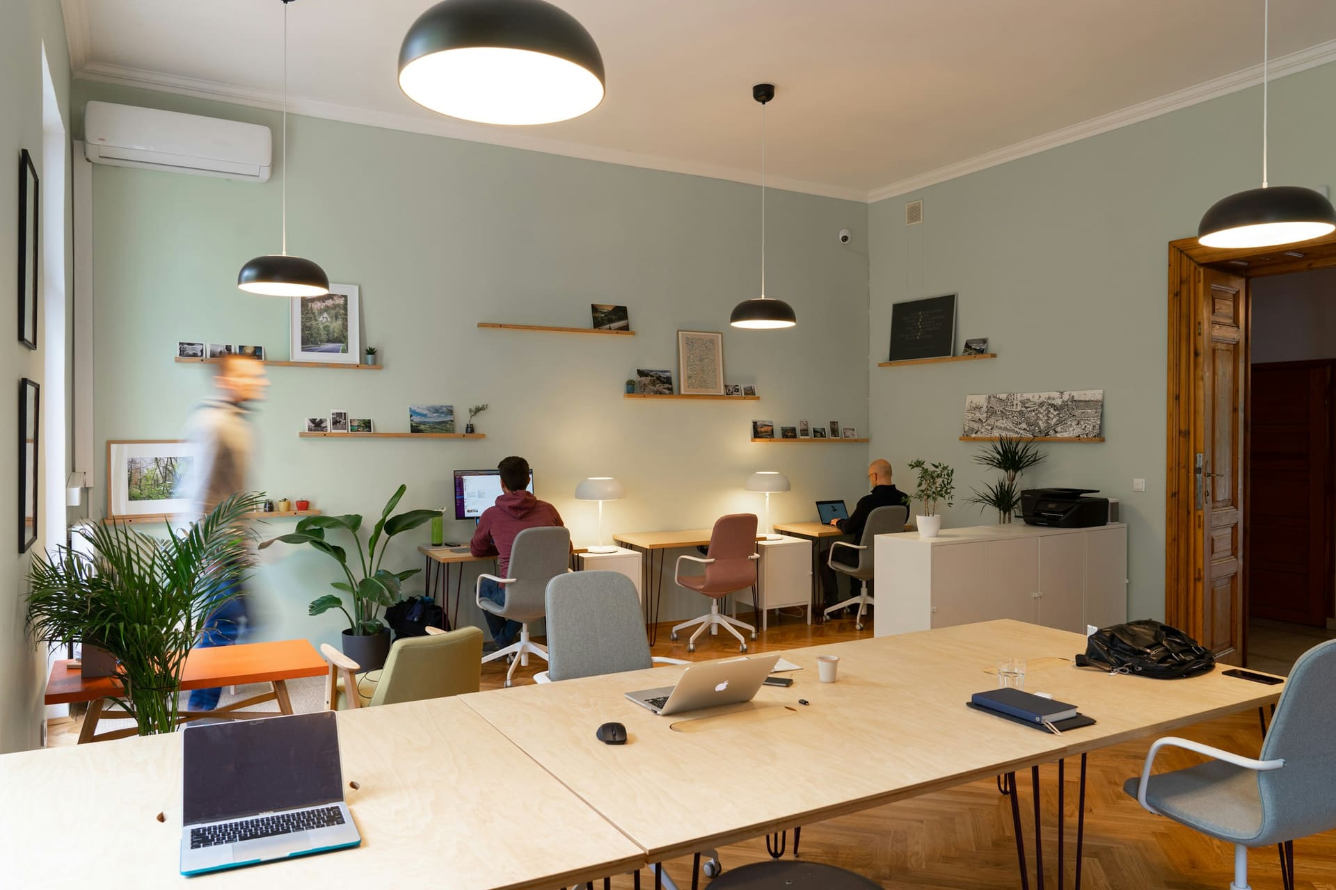 Business technology context: a shared office area with print equipment in the background.