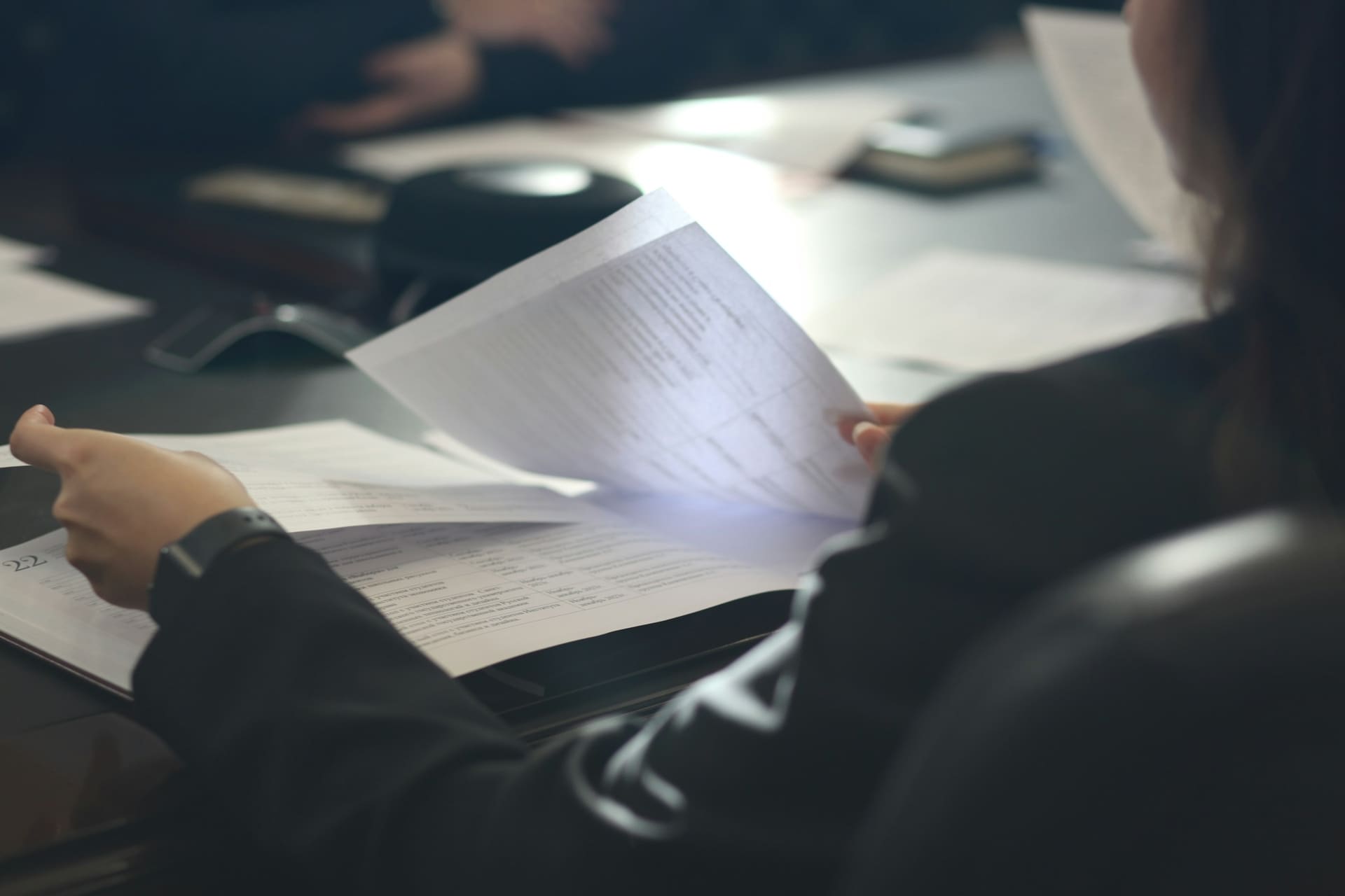 Business technology context: printed documents being handled in an office.