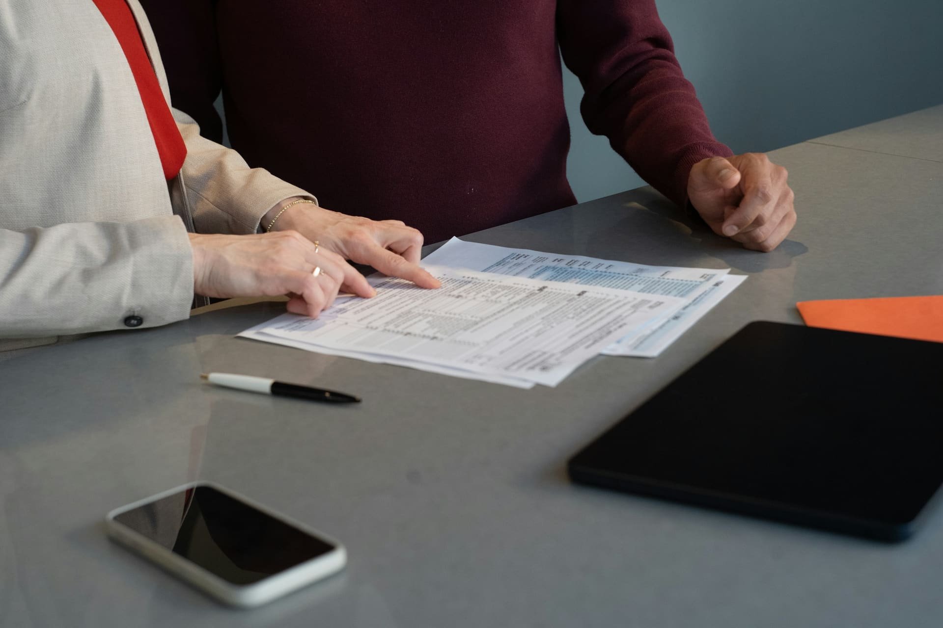 Business technology context: documents being reviewed at a desk.